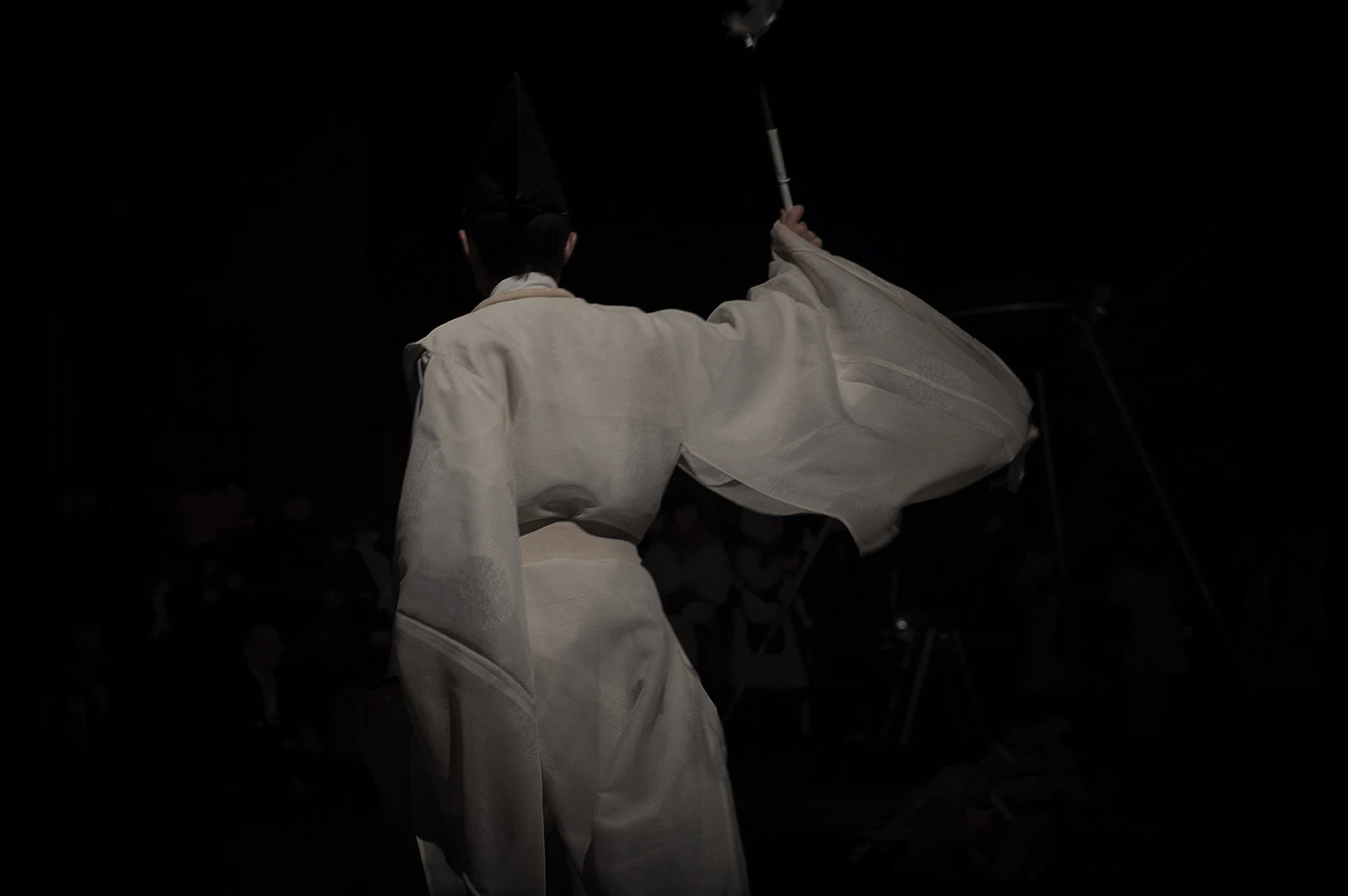 夜の境内で祓いを行う神職
