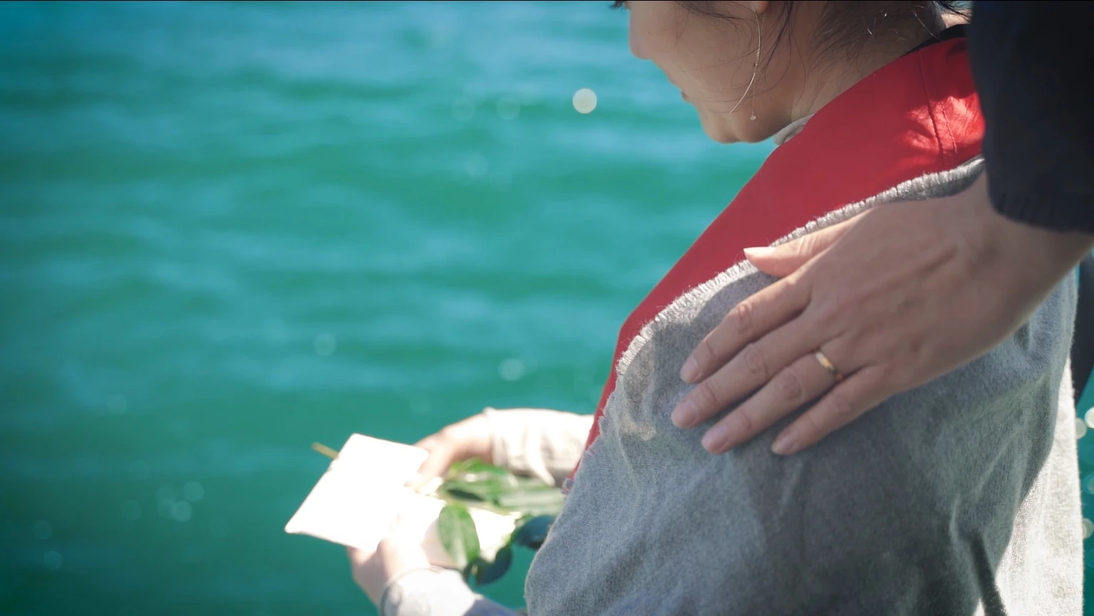 海辺で玉串を手に寄り添うご家族