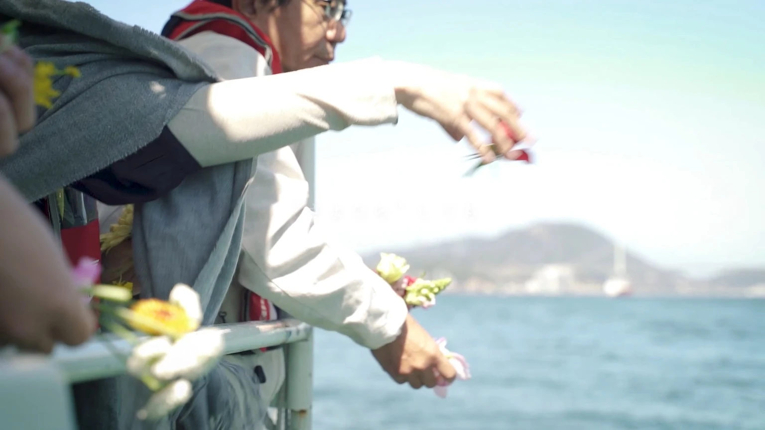 海へ花を手向けるご家族